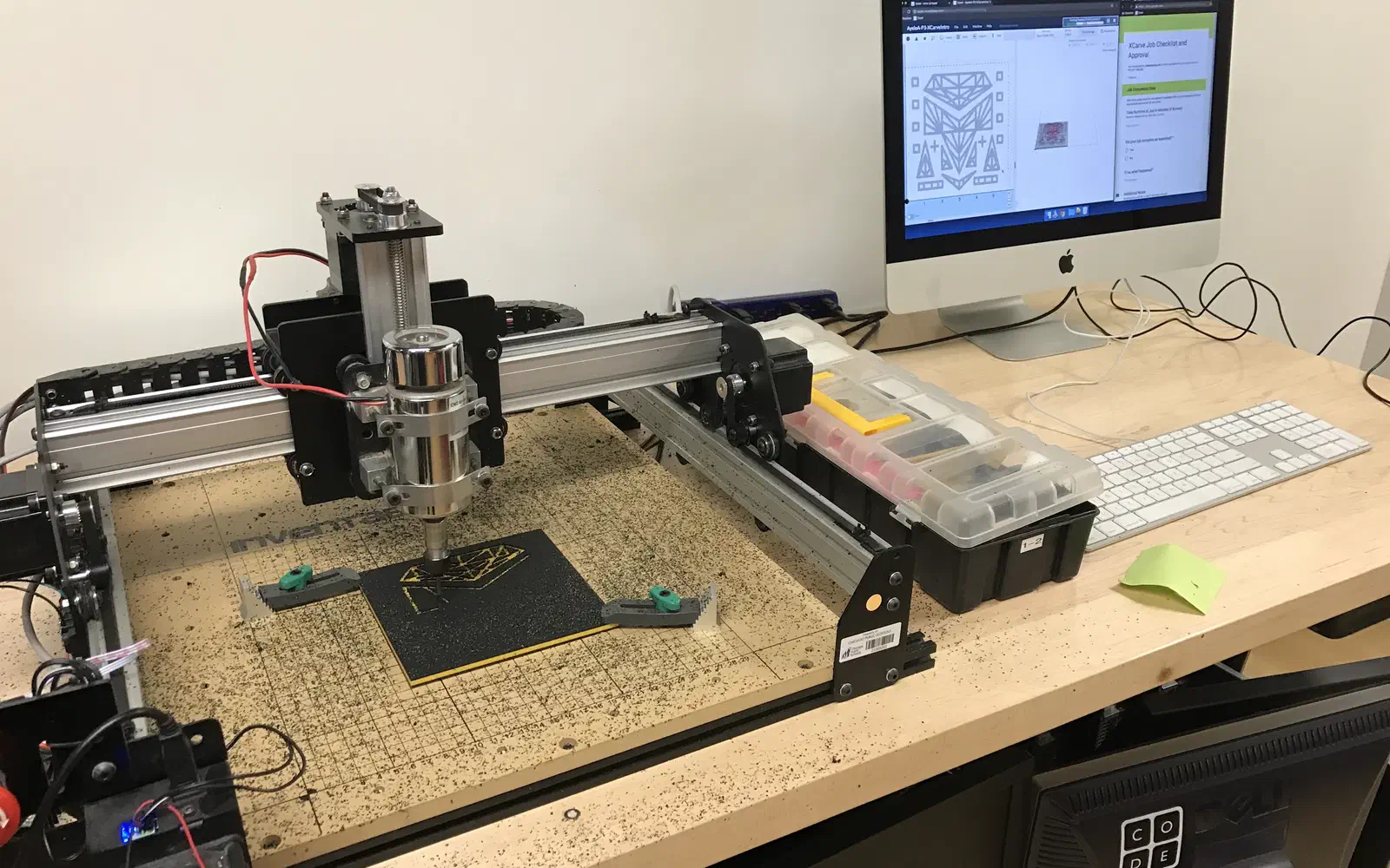 An X-Carve on a bench with Easel open on the iMac beside it, ready to carve.
