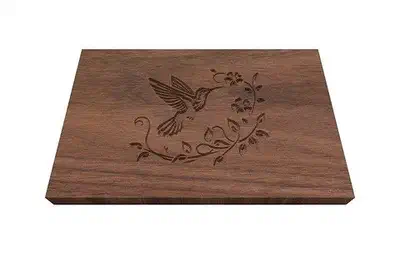 A hummingbird engraved on a walnut box lid.