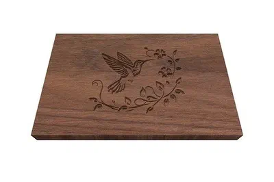 A hummingbird engraved on a walnut box lid.