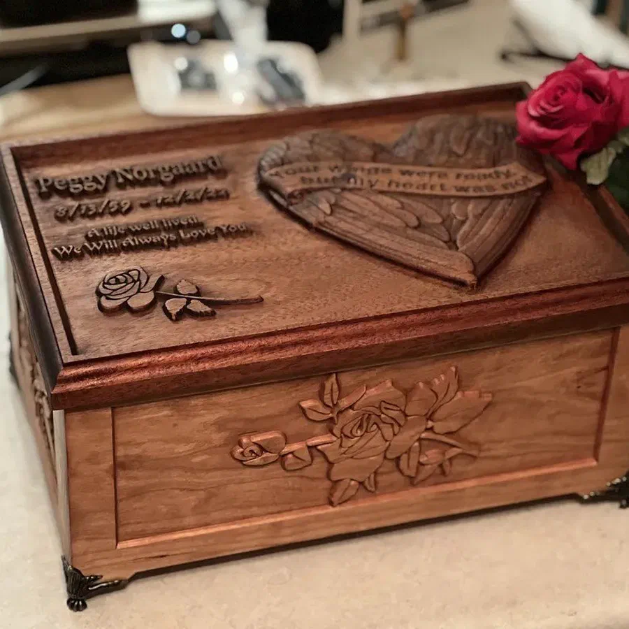A hardwood keepsake box with a three-dimensional relief carved lid of roses and a heart.