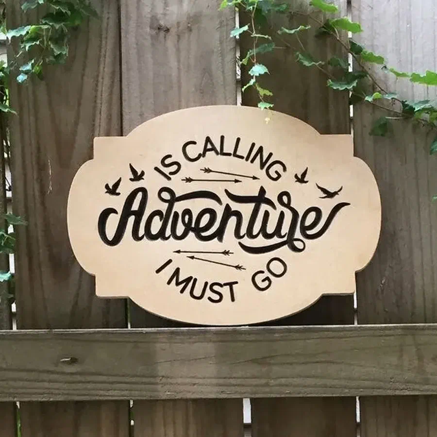 A wooden sign engraved with the phrase Adventure is calling and I must go.