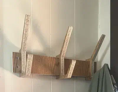 The complete upper wall rail and three angled plywood hooks of Jack Graves’s modular coat rack