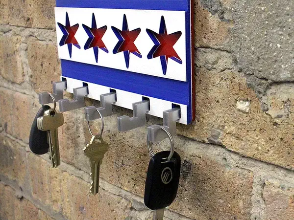 Wall-mounted Chicago flag key rack with blue stripes, red stars and five silver-colored hooks holding three key rings