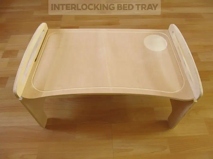 A pale plywood bed tray with handles along its raised side supports and a circular recess in the top