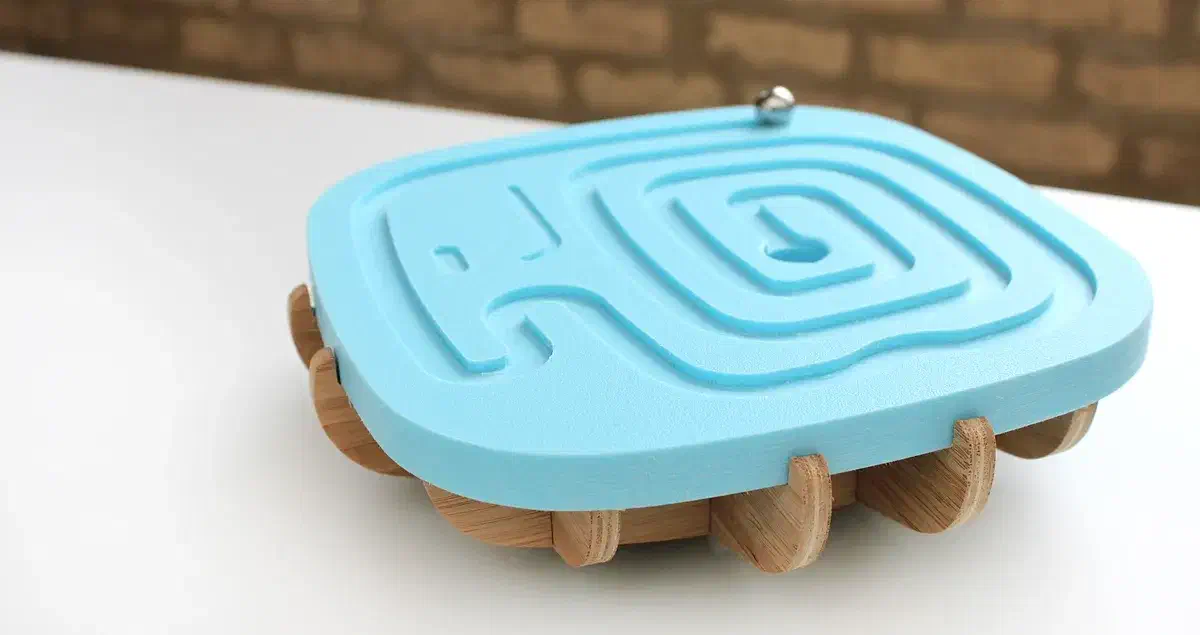 A finished blue maze top on an interlocking wooden rocking base