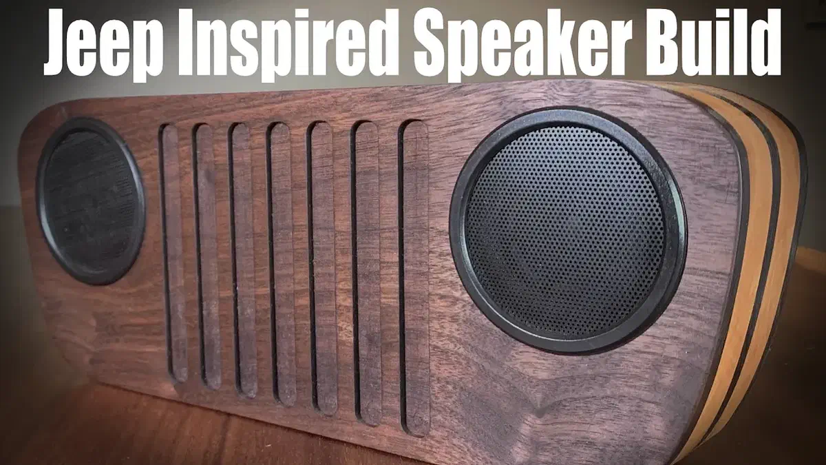 A wooden Bluetooth speaker with two dark round grilles and vertical grille-like slots, beneath the source photo's Jeep Inspired Speaker Build title