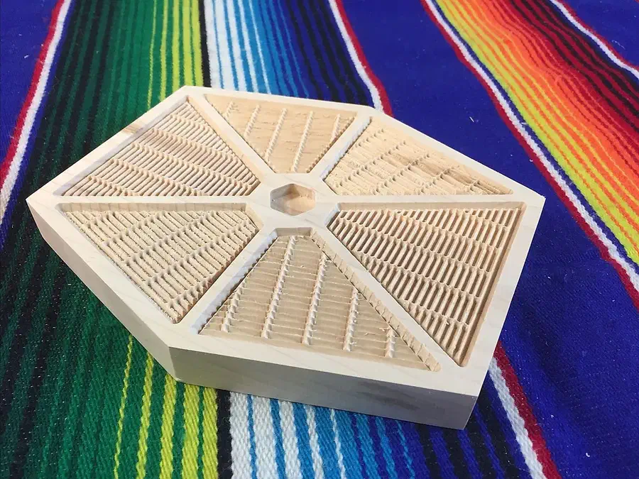 Hexagonal pale wood trivet with six finely carved fan-shaped panels