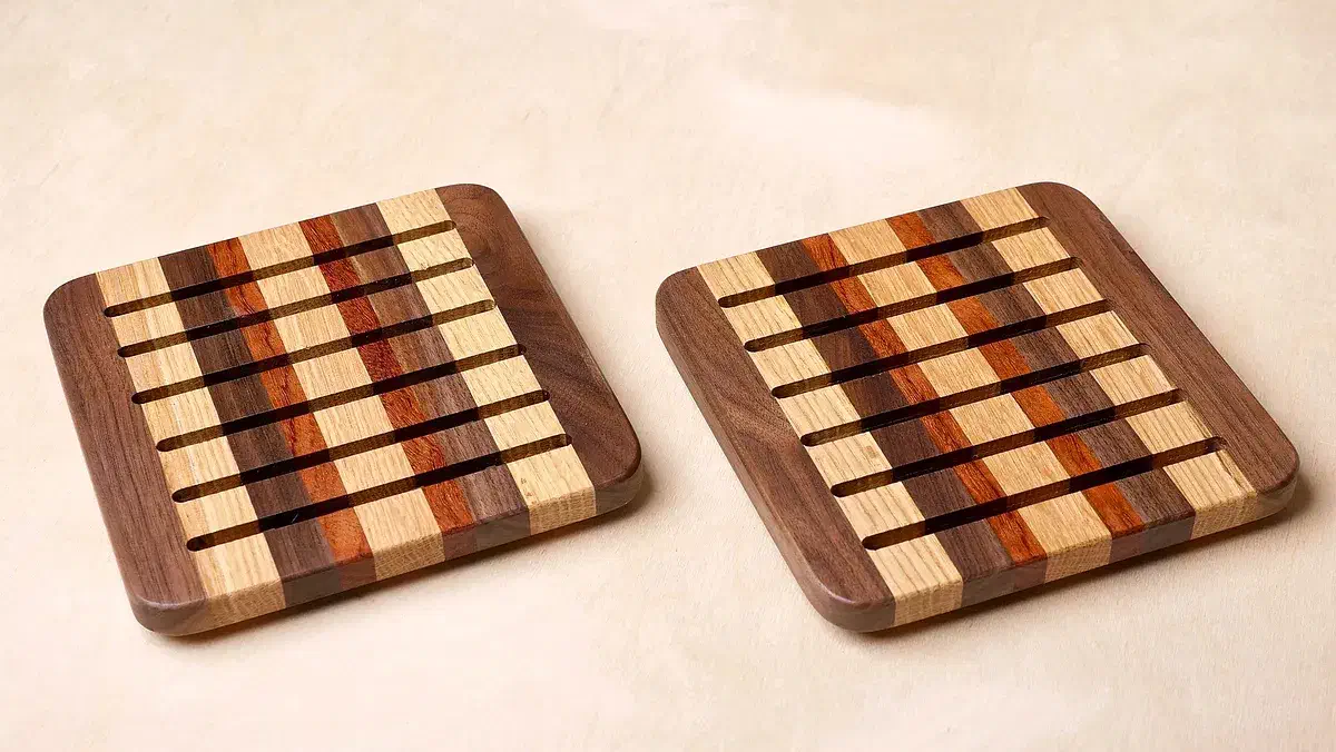 Striped scrap-wood trivets with parallel slots and rounded corners