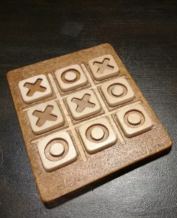 A small wooden tic-tac-toe board with shaped X and O pieces in recessed squares